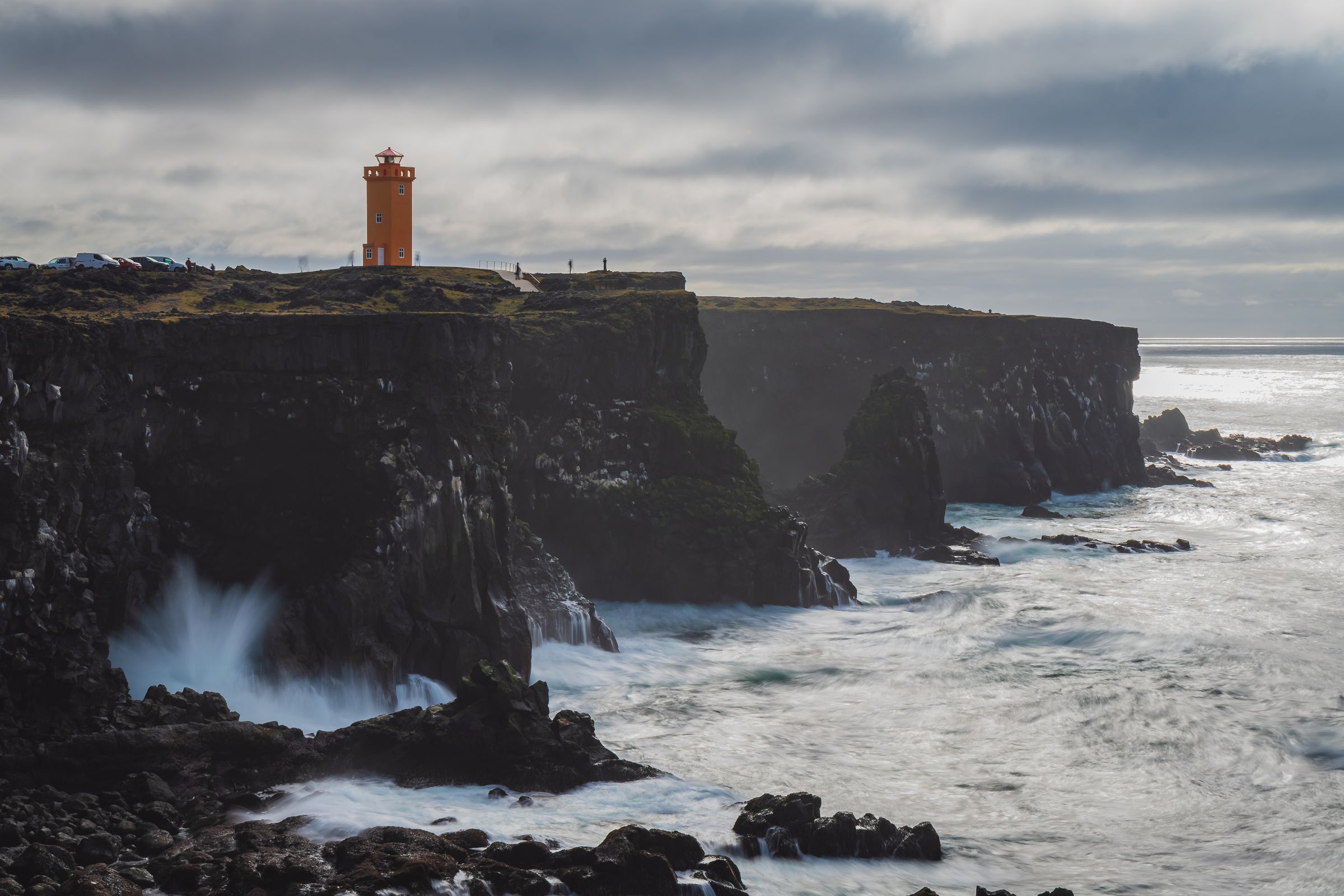 a lighthouse on top of a cliff overlooking the ocean .