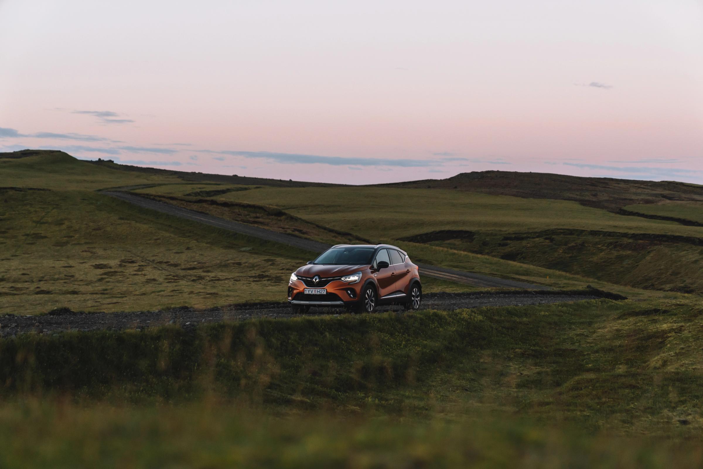 Renault Captur Iceland road trip vehicle parked on a gravel road through open green hills