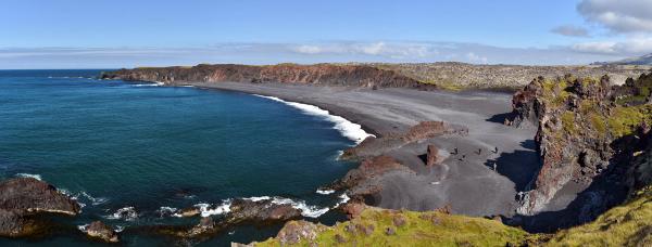 una vista panorámica de una playa de arena negra junto al océano .