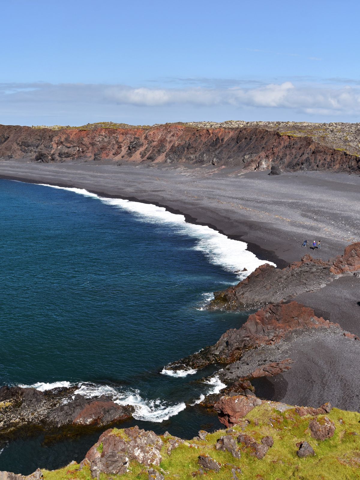 una vista panorámica de una playa de arena negra junto al océano .