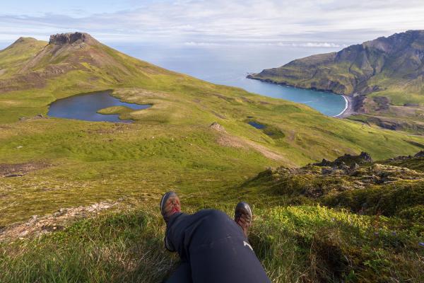 Chica sentada después de hacer senderismo por el este de Islandia