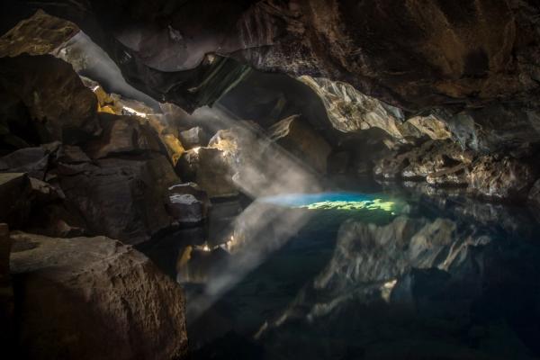 the sun is shining through the ceiling of a cave .