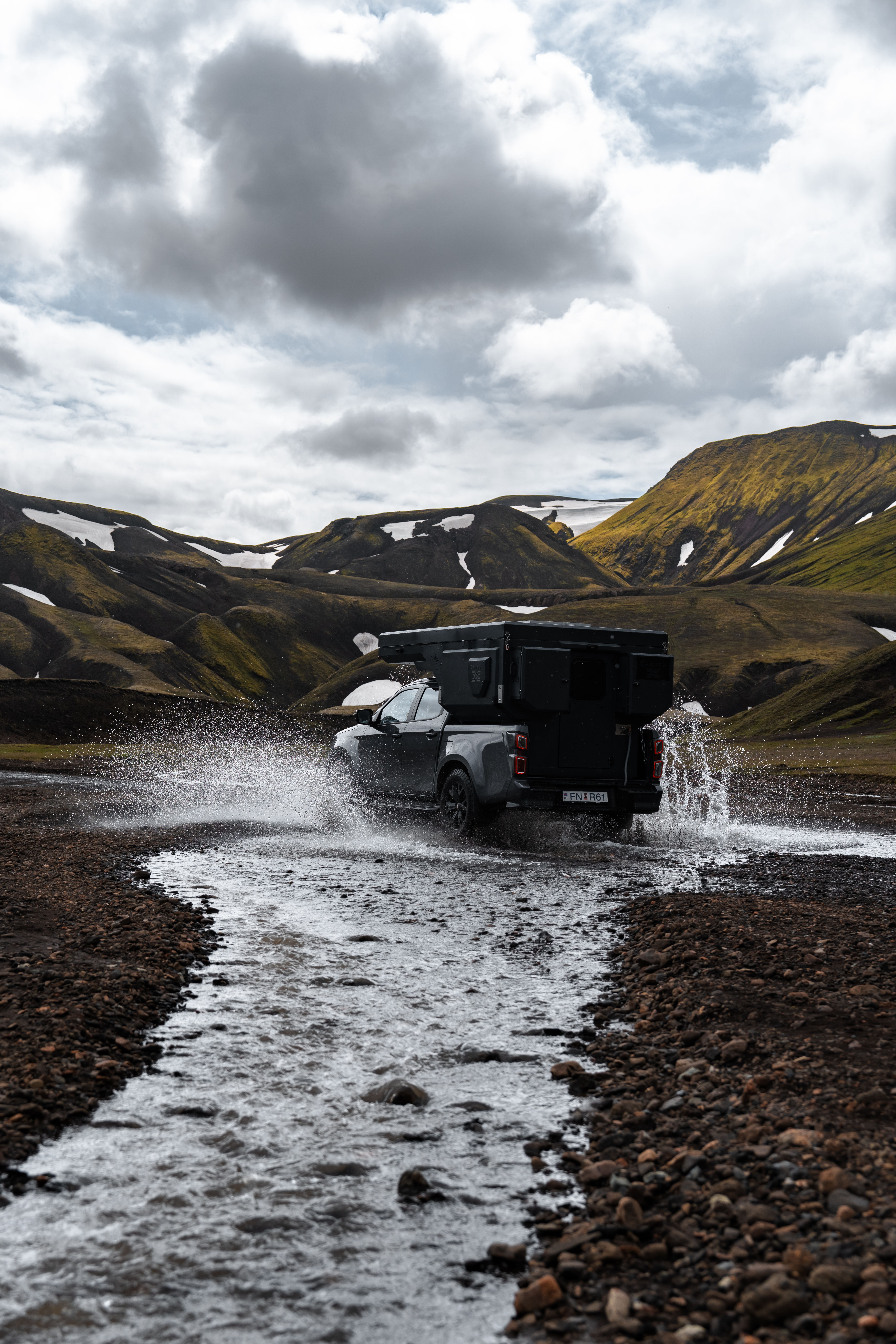 Una autocaravana 4x4 para 2 personas cruzando un río, vista desde atrás, alquiler de autocaravanas en Islandia
