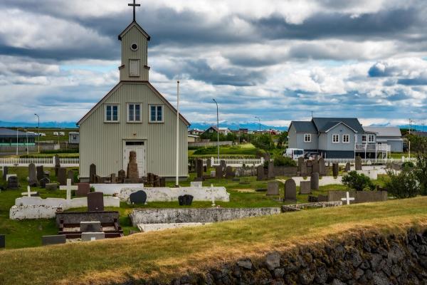 una iglesia y casa de madera que pertenecen a un pequeño pueblo