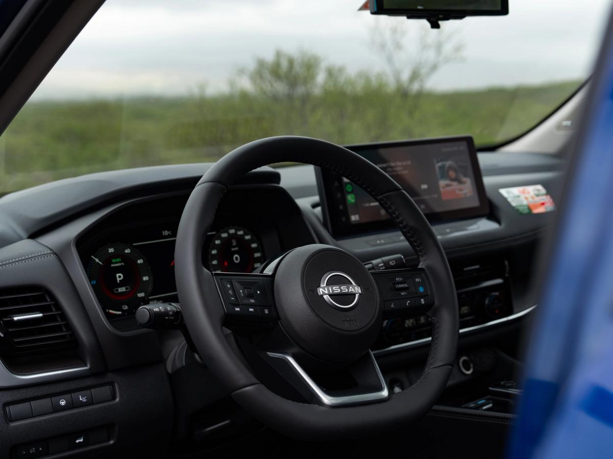 Vista del panel de control de X-Trail Vista interior del Nissan X-Trail con el volante y la pantalla del sistema de infoentretenimiento