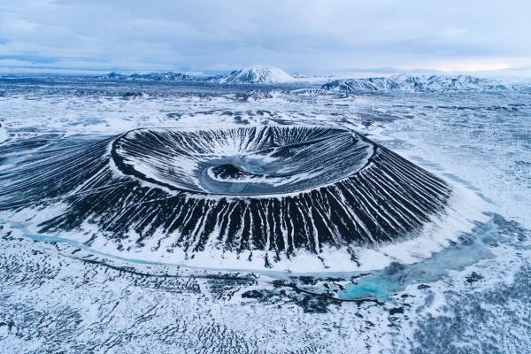 an aerial view of a volcano in the middle of a snowy field at lake myvatn in iceland.