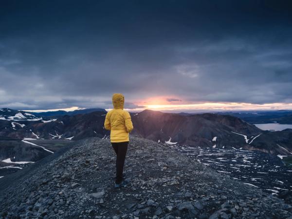 Hiker with the Midnight Sun in the horizon