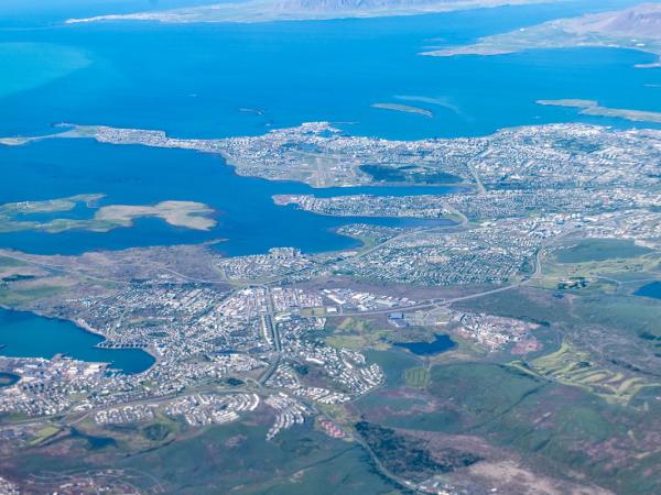 an aerial view of a city surrounded by water and mountains .