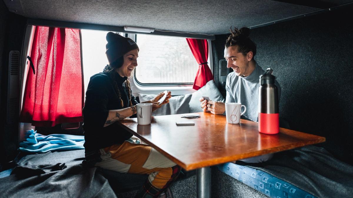 un homme et une femme sont assis à une table dans un van.