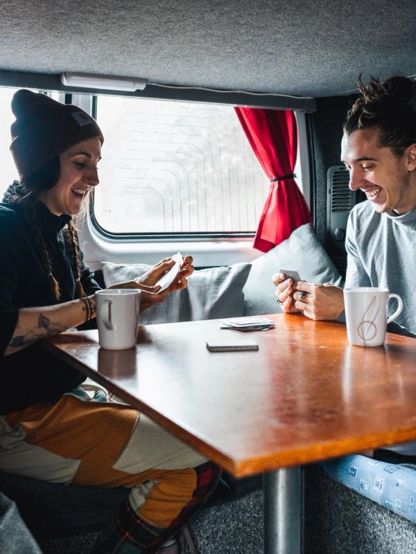 un homme et une femme sont assis à une table dans un van.