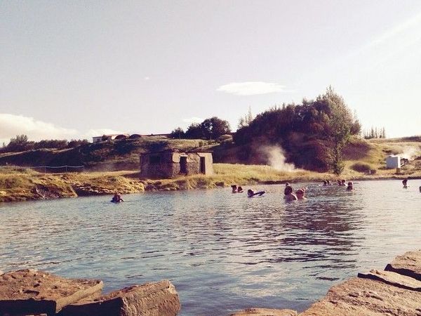 a group of people are swimming in a lake surrounded by rocks .