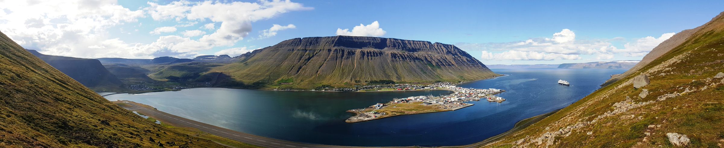 une vue panoramique d'un lac entouré de montagnes et de la ville d'Ísafjörður