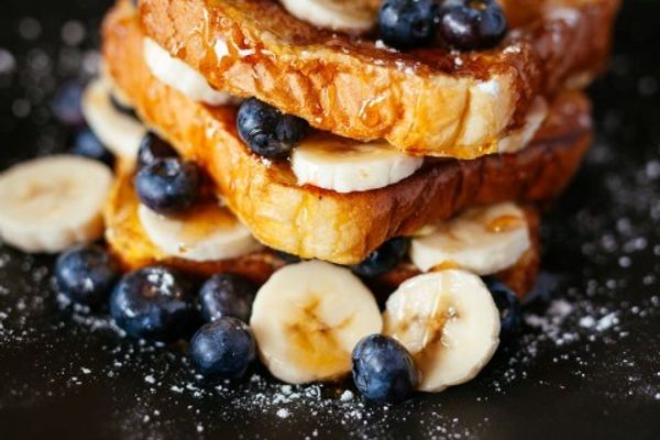 french toast with bananas and blueberries on a black plate in iceland.