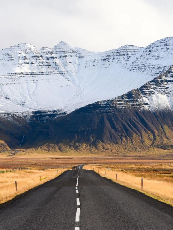 Carretera espectacular en Islandia con montañas nevadas de fondo