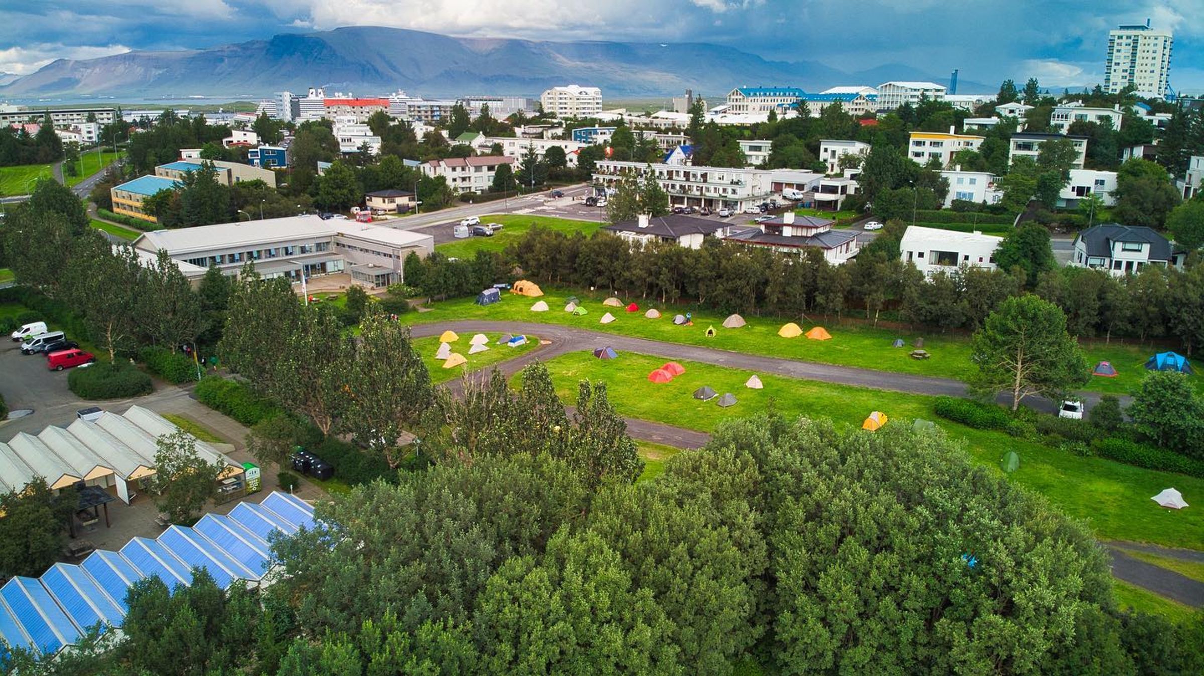 Aerial image of a campsite full of tents surrounded by trees and houses