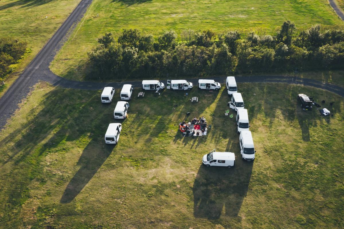 Vista aérea de una grupo de furgonetas aparcadas en un campo.