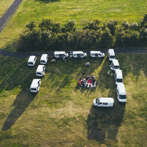 an aerial view of a group of vans parked in a field .