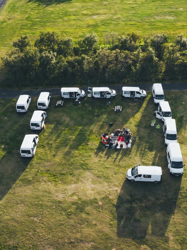 an aerial view of a group of vans parked in a field .