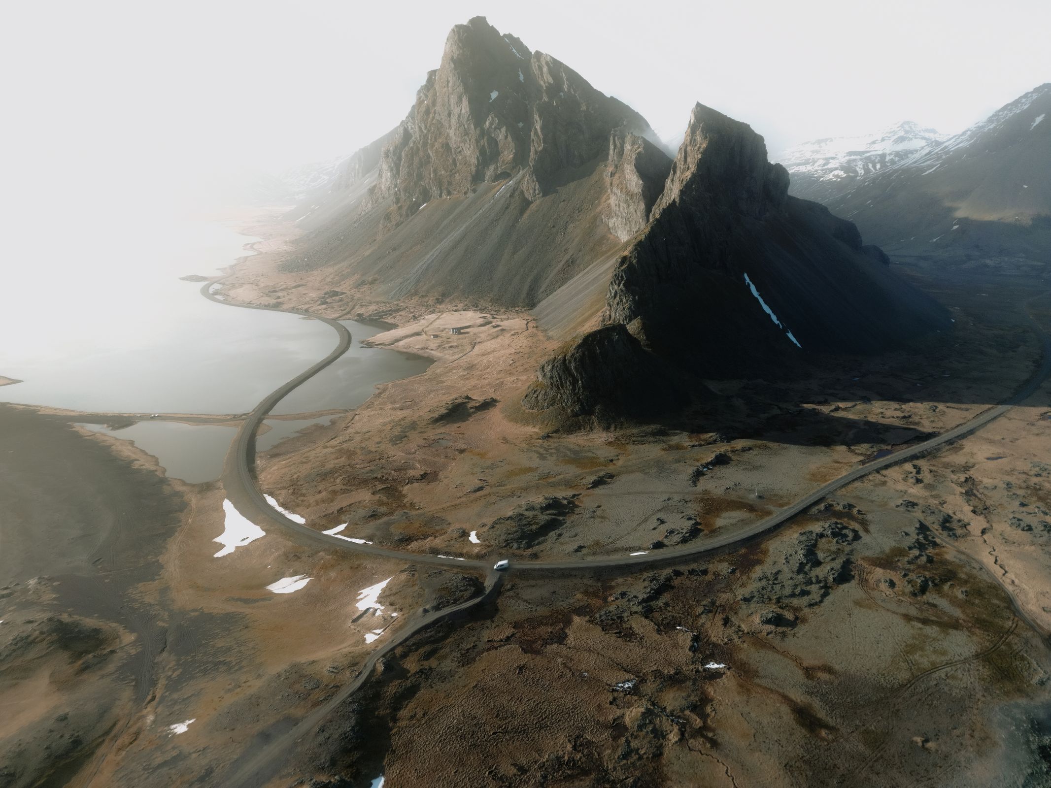 an aerial view of a mountain range with a road going through it .