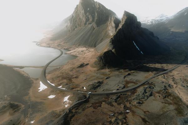 an aerial view of a mountain range with a road going through it .