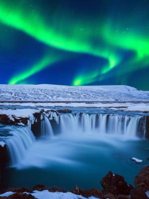 Must-Sees in North Iceland Northern Lights at Godafoss waterfall in winter, north Iceland.