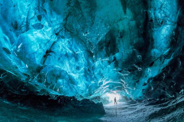 a person is standing in the middle of an ice cave in iceland.