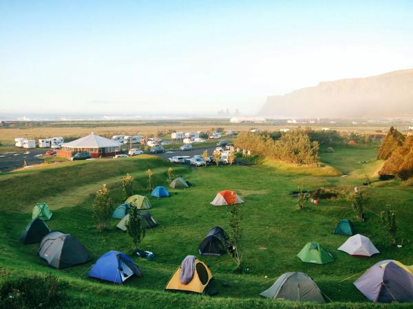 tents on a grass field with the ocean on the background