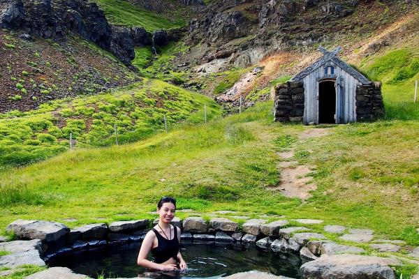 a woman is sitting in a pool of water in a field .