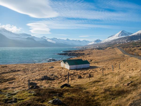 a landscape with a fiord and mountains covered by snow