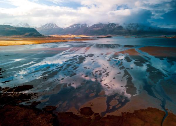 an aerial view of a lake with mountains in the background .