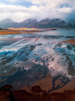 una vista aérea de un lago con montañas al fondo .