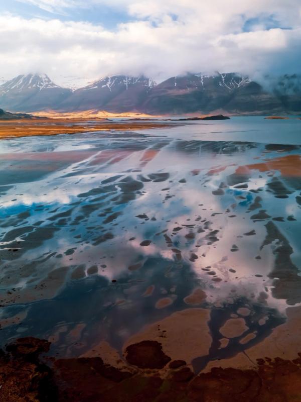 an aerial view of a lake with mountains in the background .