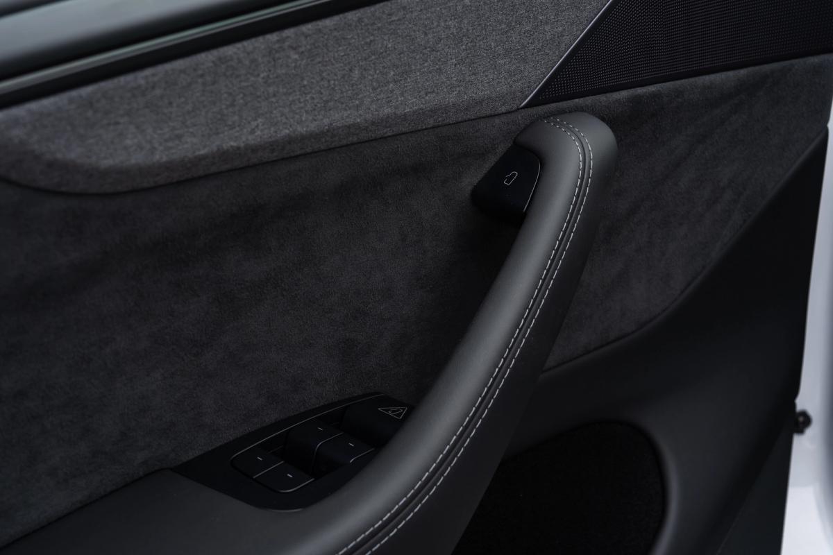 Primer plano de la manija de la puerta y los controles de las ventanillas de un Tesla Model Y, coche de alquiler en Islandia