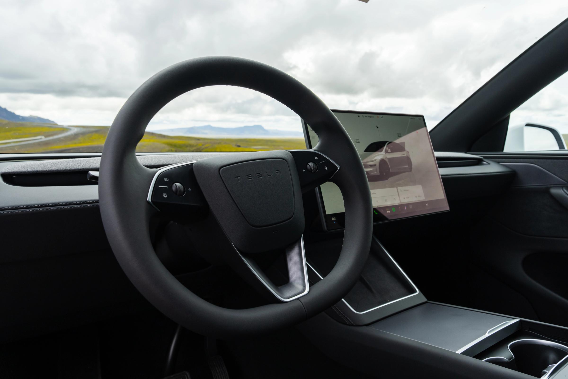 Interior de un Tesla Model Y con el volante y la pantalla táctil, vehículo para recorrer Islandia por cuenta propia