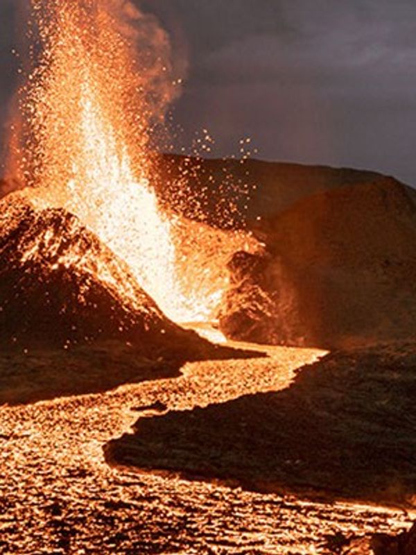 a volcano is erupting and lava is coming out of it .