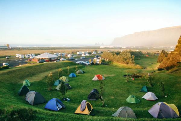 a group of tents are sitting on top of a lush green field