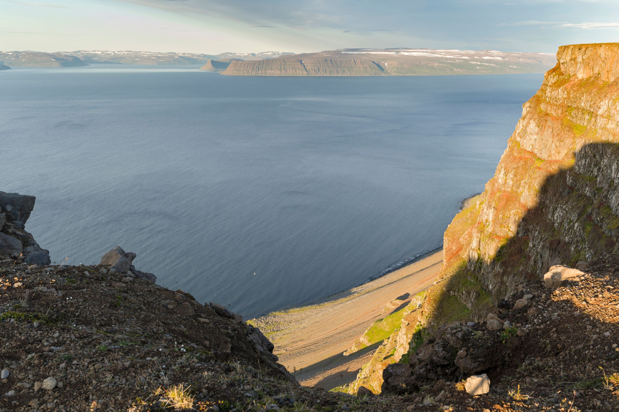 une vue sur un grand étendue d'eau depuis une falaise