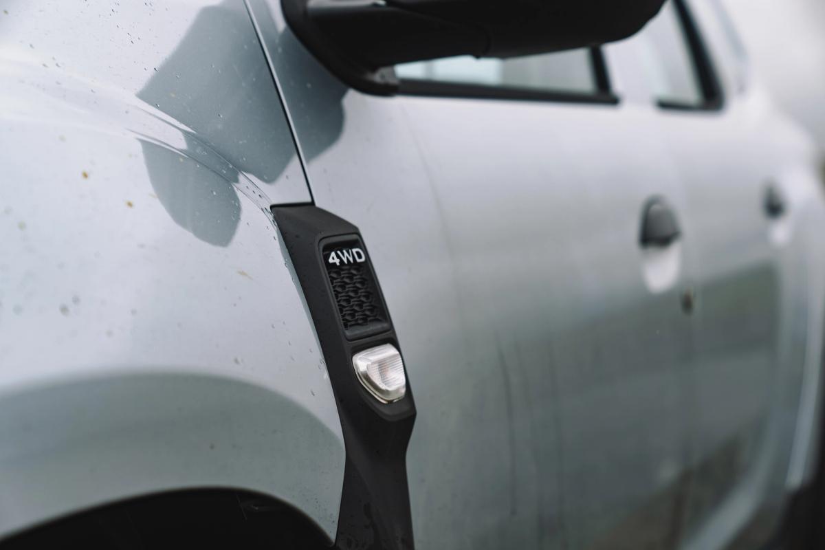 Dacia Duster close up of 4WD badge and door handle on white exterior panel