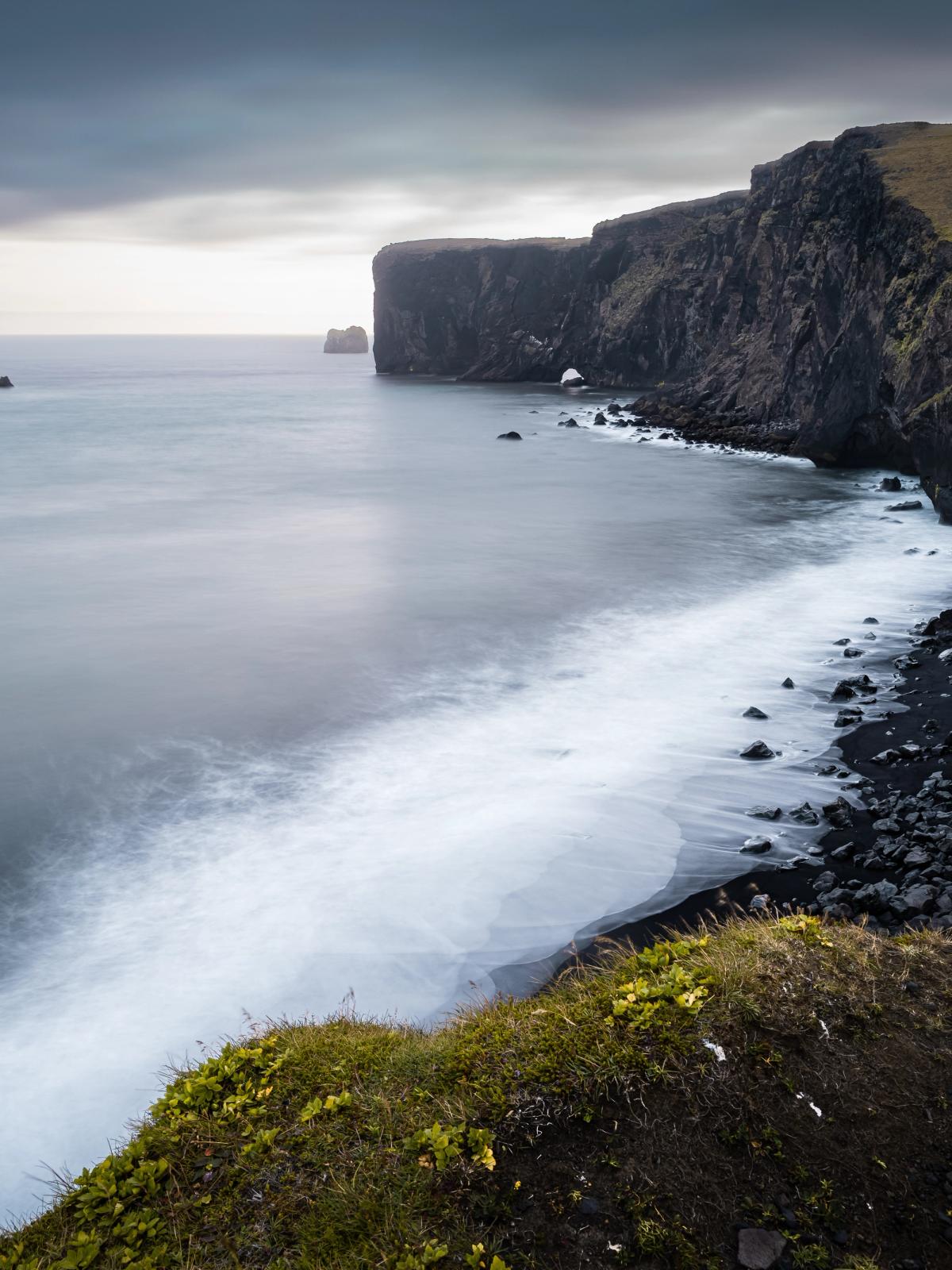 une photo en pose longue d'une falaise surplombant l'océan.