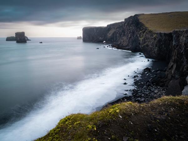 a long exposure photo of a cliff overlooking the ocean .