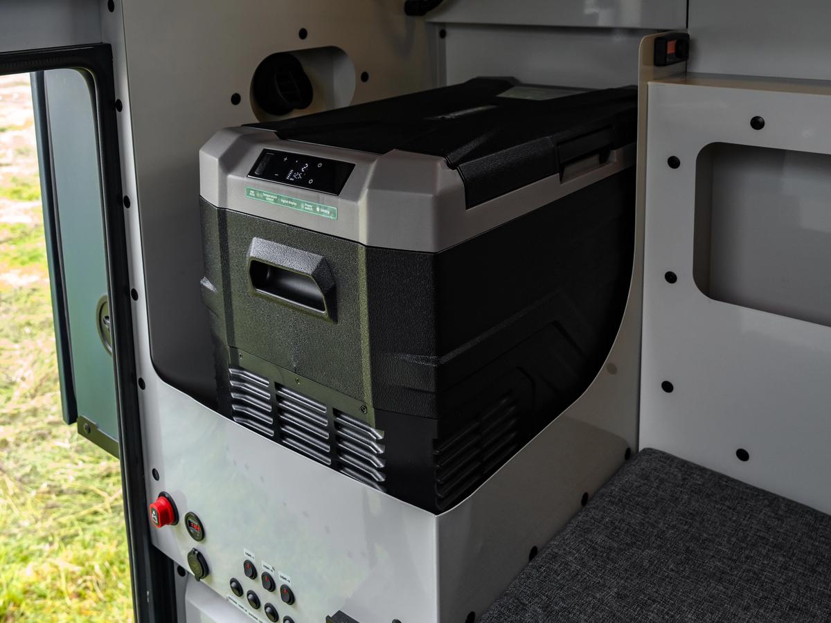 Armario refrigerado Nevera eléctrica portátil con pantalla digital en un armario situado encima de un panel de interruptores y enchufes