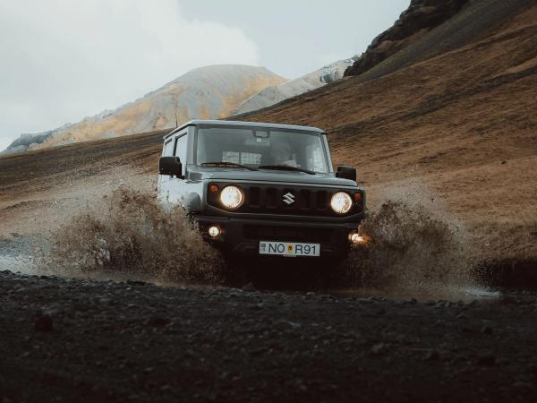 Coche cruzando un charco con las luces encendidas