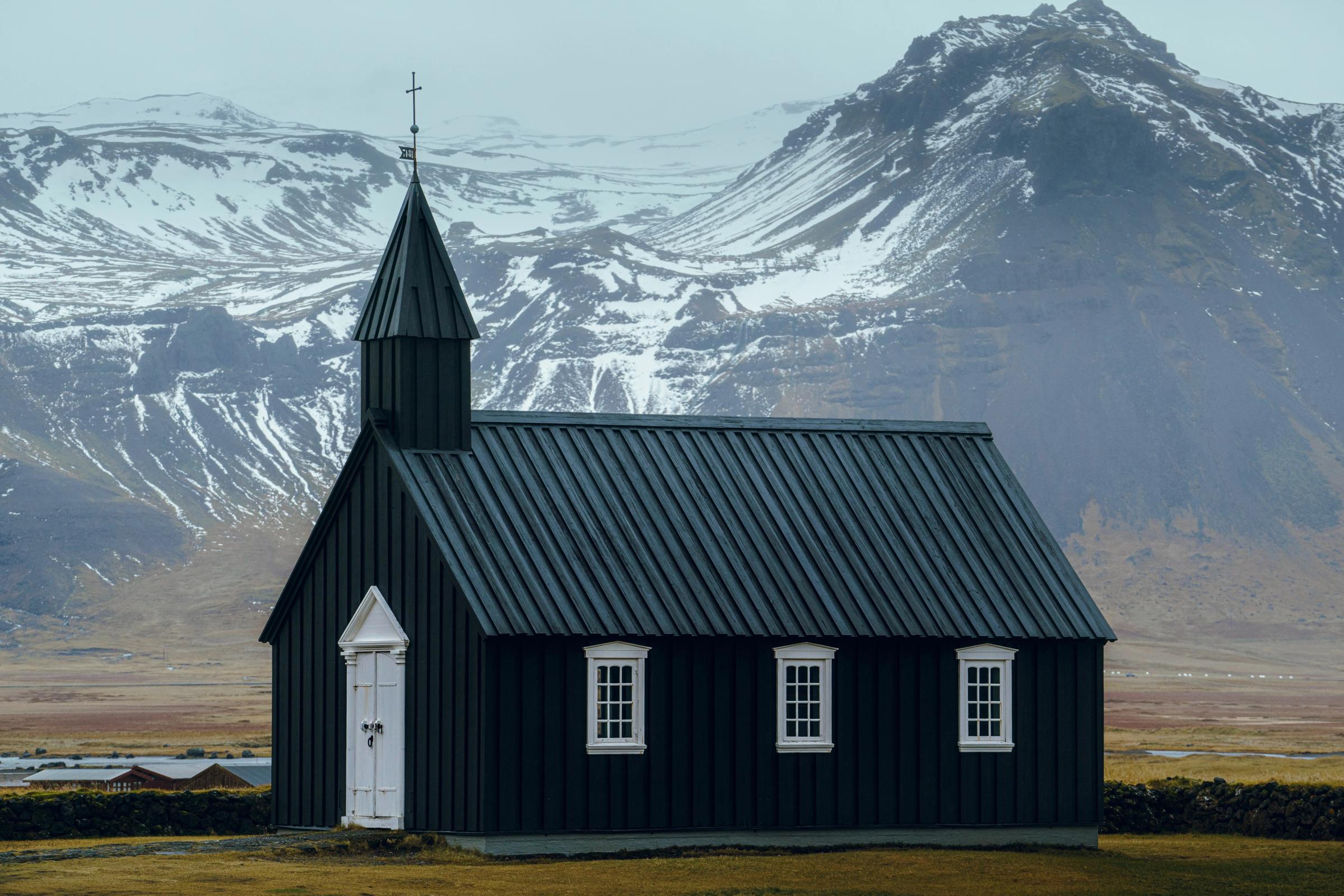 View on the Budir black church and the snowy mountains in the background  