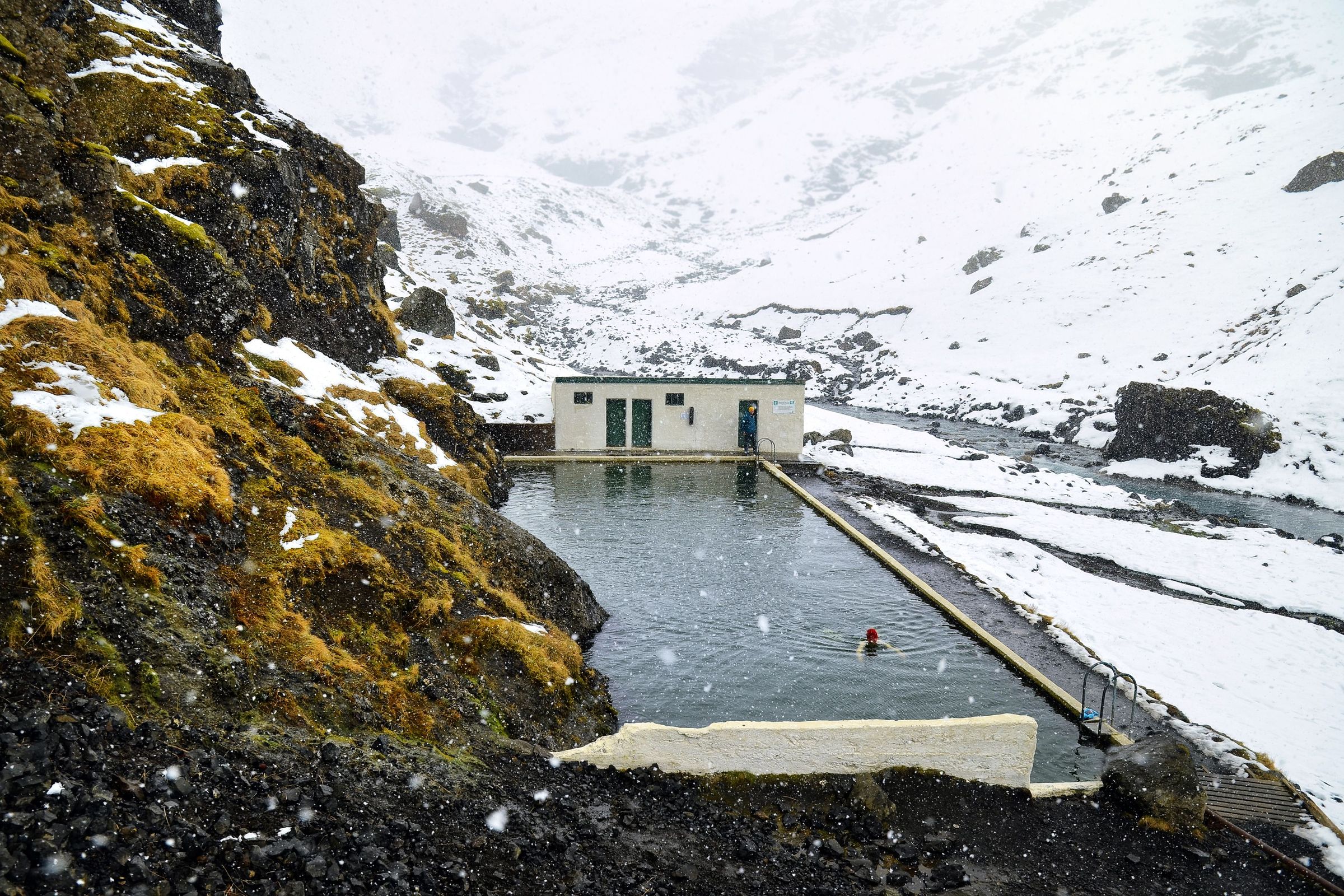a concrete pool in a valley covered by snow