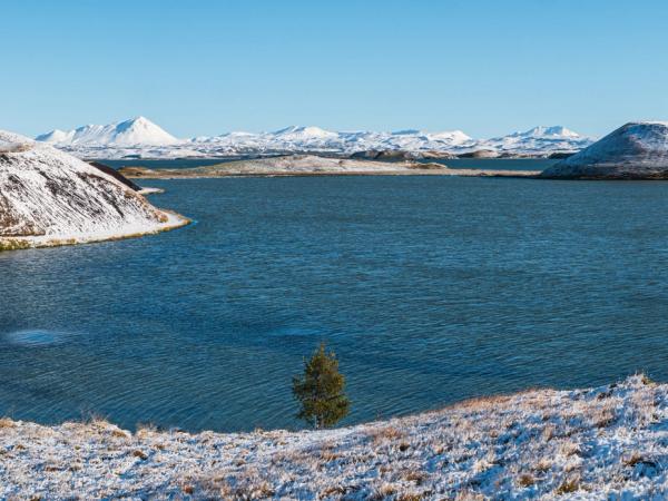 volcanic crater covered by snow by a quiet lake