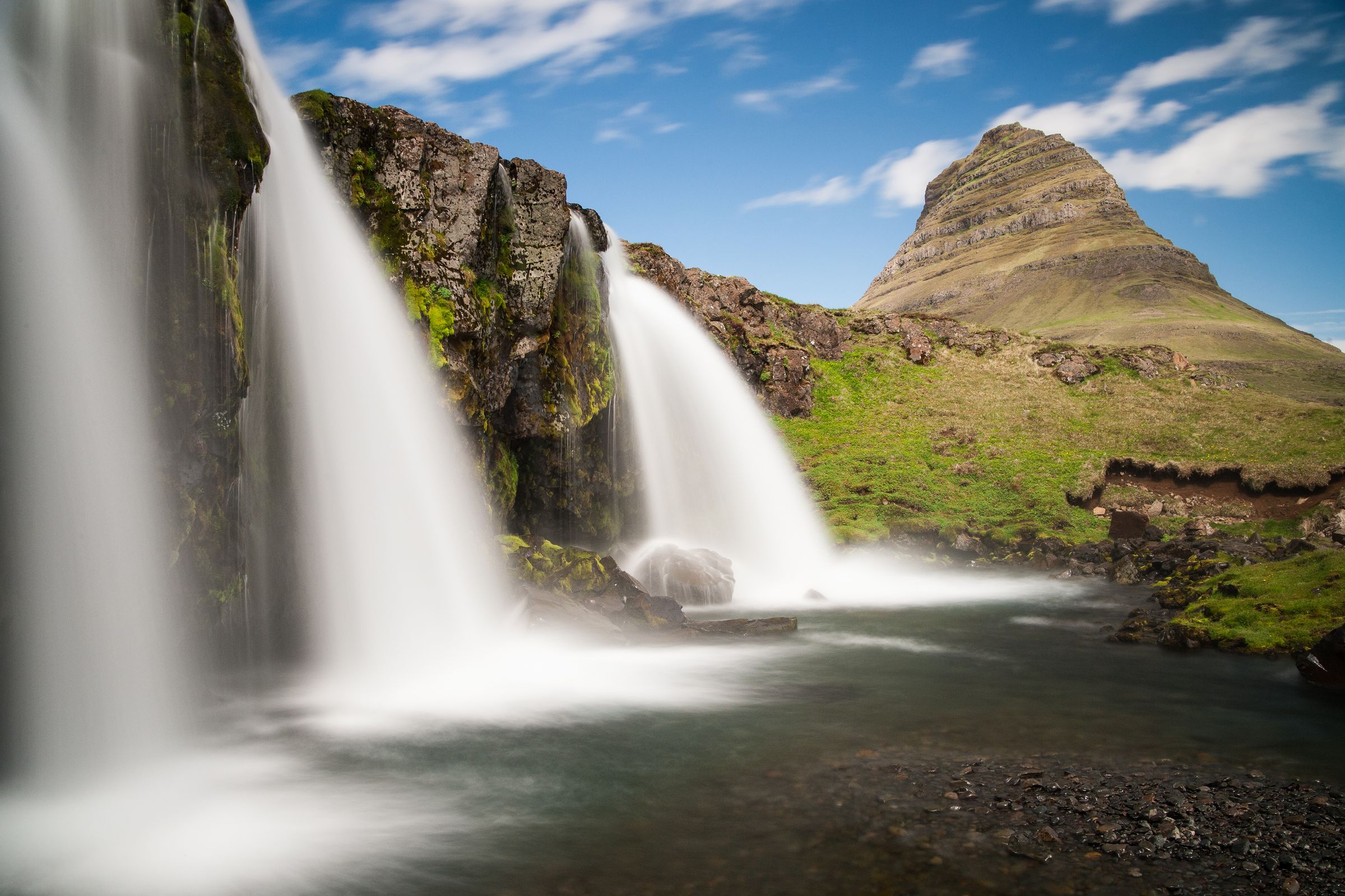 Long exposure of Kirkjufellsfoss waterfall with Kirkjufell mountain in the background.