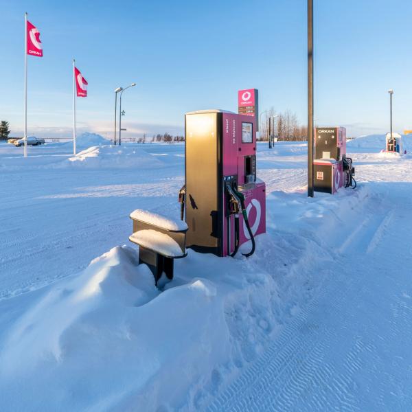 a gas pump is covered in snow at a gas station .