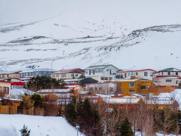 Colorful houses in a snow-covered village with a large mountain backdrop.