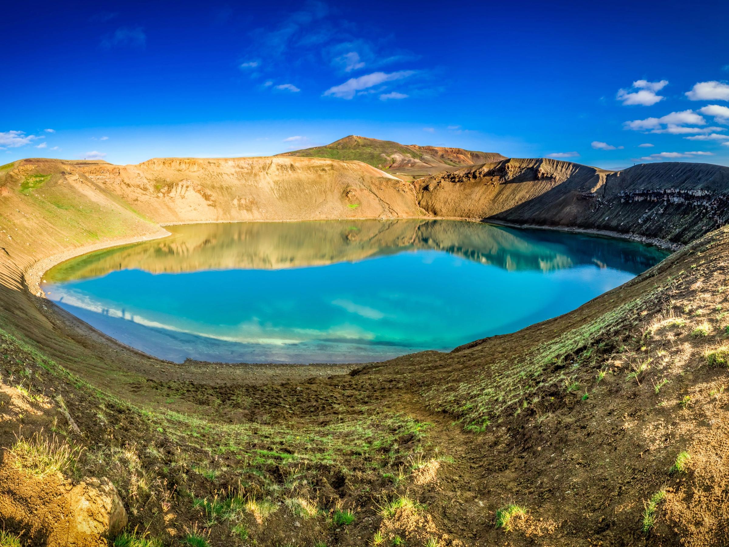 a large blue lake in the middle of a desert surrounded by mountains .