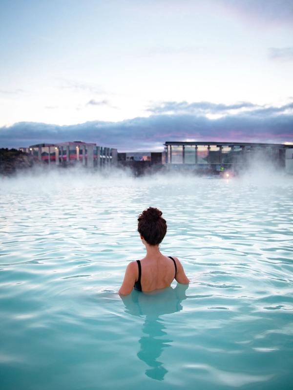 Volcanic hot springs A woman relaxing in a geothermal pool also known as hot springs in iceland that has warm water with perfect temperature